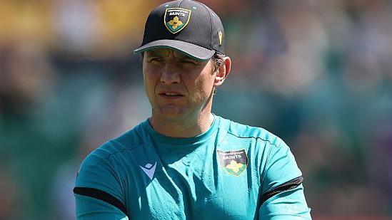 Northampton Saints director of rugby Phil Dowson watching his team train before kick-off with his arms folded.