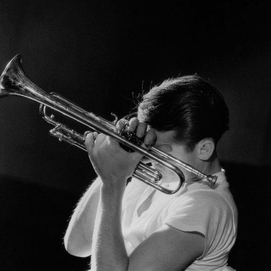 A black and white image of Chet Baker holding a trumpet in New York City in 1956.