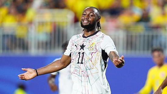 Antoine Semenyo stands with arms outstretched looking frustrated