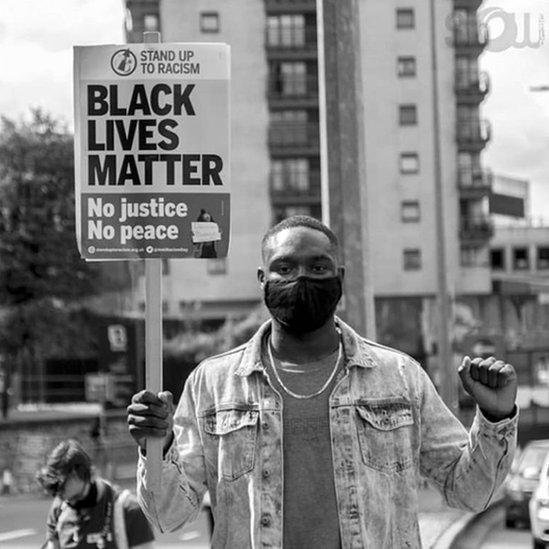 Andrew Ogun mewn protest Black Lives Matter