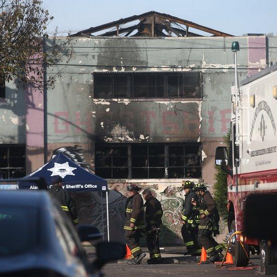 A mourner cries at a memorial near the burned warehouse in December 2016