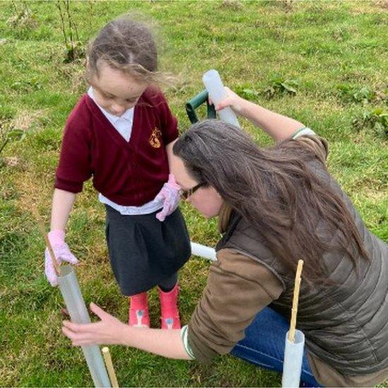 Kaye Squire and her daughter Willow, planting trees on the farm