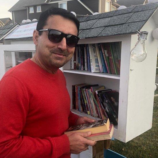 Syed Najam Hassan in front of a bookshelf