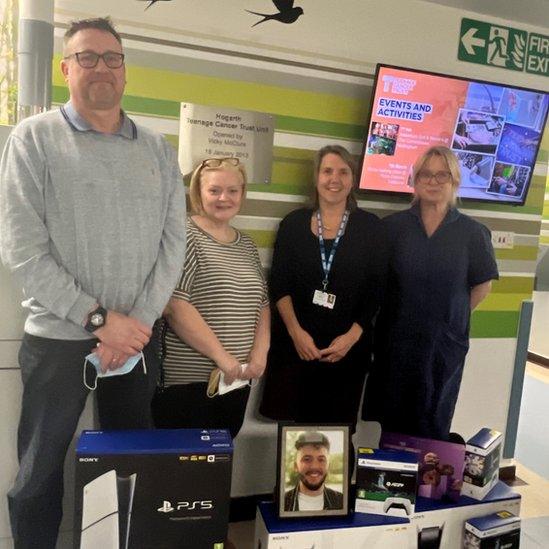 The family and staff at the hospital pose with the games consoles