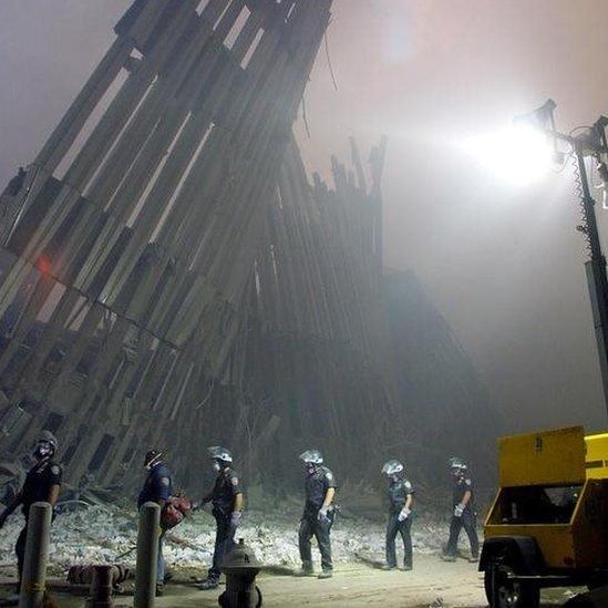 Firefighters inspect the rubble of the World Trade Center in New York. Photo: 11 September 2001