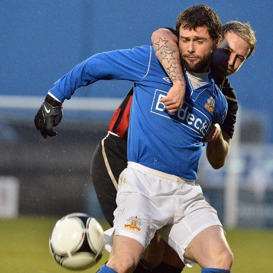 Glenavon player manager Gary Hamilton is closely marked by Crusaders opponent Aiden Watson at Mourneview Park