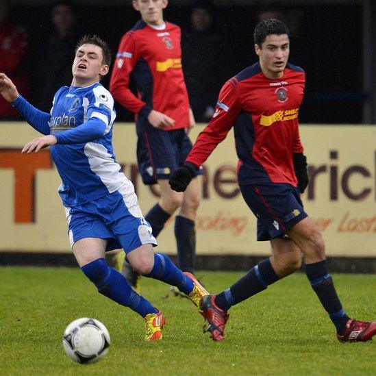 Dungannon's PJ Harvey in action against Andrew Ferguson of Lisburn Distillery