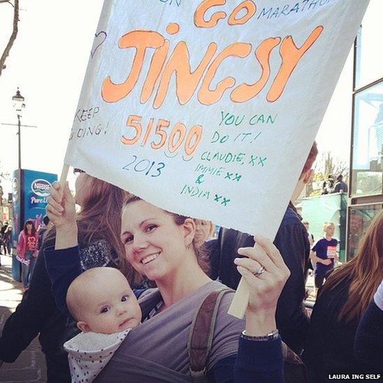 Woman holds banner encouraging a runner. Photo: Laura Ing Self