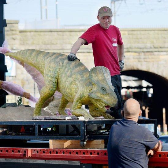 Staff take a break from unloading a delivery of dinosaurs