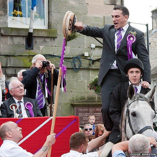 The nailing of a salted herring to a barley bannock is one of the most dramatic elements of the Langholm celebrations