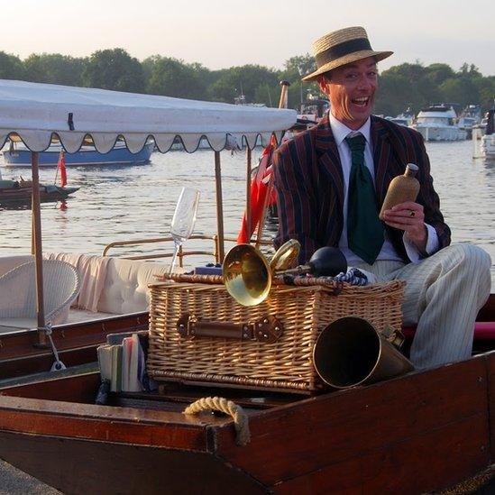 An actor taking part in the Henley Festival "roving eccentrica" aboard a motorised punt.