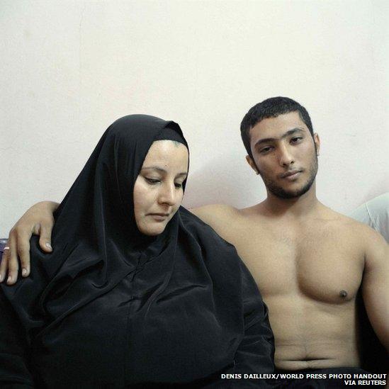 A young Egyptian bodybuilder, posing with his mother in Cairo