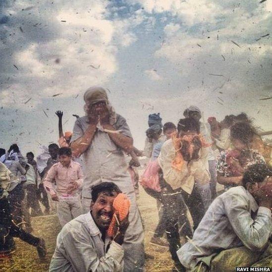 Supporters are engulfed in a momentary dust storm induced by BJP candidate Narendra Modi's helicopter, as he departs from a public meeting in Robertsganj, Varanasi.