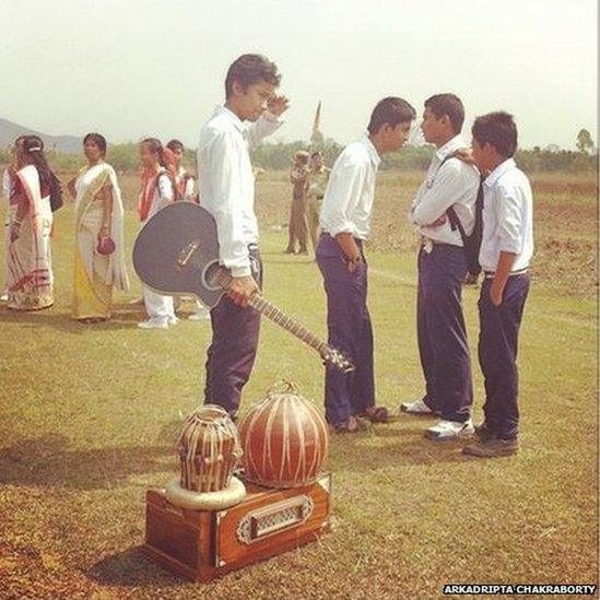 School students with musical instruments wait to greet Narendra Modi at Kakoijana field in Bongaigaon, Assam.