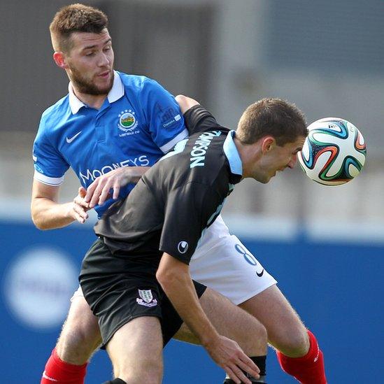 Linfield's Stephen Lowry and Gary Thompson of Ballymena United in a midfield tussle at Windsor Park