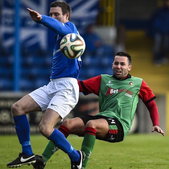 Kevin Braniff of Glenavon in action against Glentoran's Niall Henderson at Mourneview Park