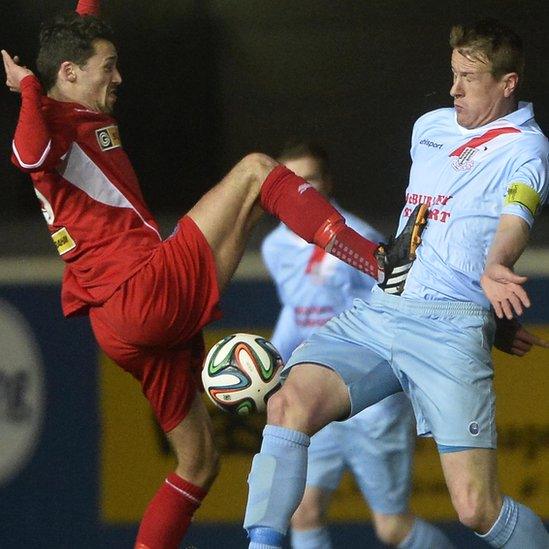 Cliftonville's Tomas Cosgrove goes in high on United captain Allan Jenkins