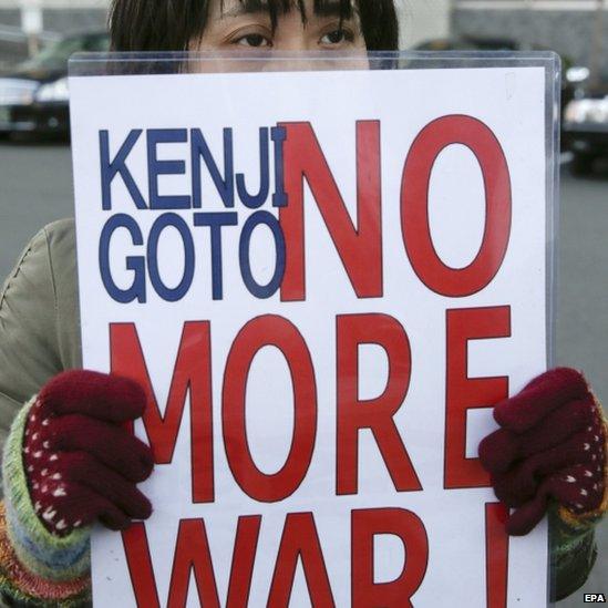 A protester holds a placard outside PM Abe's residence in Tokyo. Photo: 1 February 2015