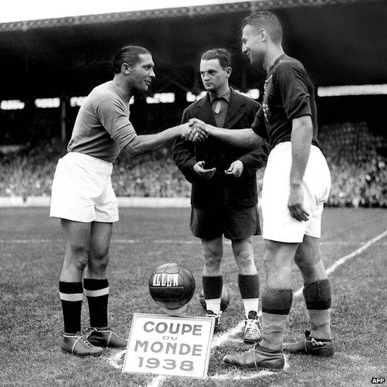 French referee Georges Capdeville (C) looks on as the captains of the Italian and Hungarian national soccer teams shake hands before the start of the World Cup final between the two countries (19 June 1938)