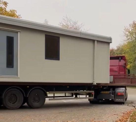 A cabin on a transporter lorry being driven out of the Scampton site