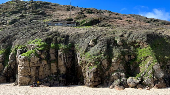 The bungalow on the cliff seen from the beach below