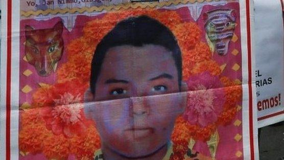 A relative of a missing student holds a poster with the image of Christian Alfonso Rodriguez Telumbre, as she takes part during a march to mark the disappearance of the 43 missing Ayotzinapa College Raul Isidro Burgos students in the state of Guerrero, along the streets in Mexico City, Mexico, September 26, 2018