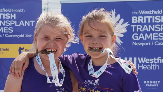 Two children pose with their medals from the games 