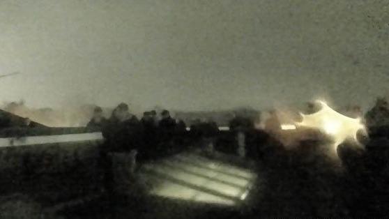 A grainy CCTV still from the rooftop of a building showing a large group of youths gathered near a skylight at 17:06 on 23 November 2024