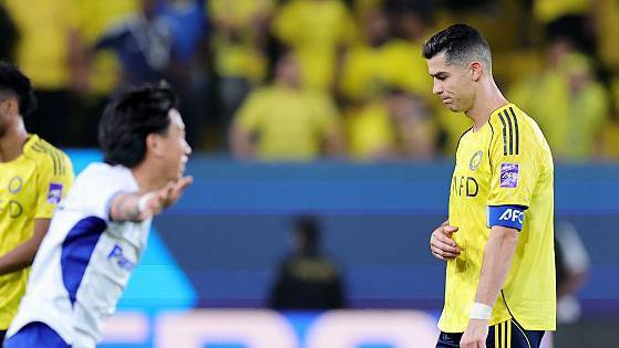 Al-Nassr's Cristiano Ronaldo looks disappointed as Gamba Osaka celebrate after winning the AFC Champions League Two final