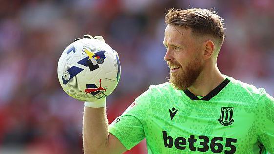 Stoke City goalkeeper Viktor Johansson grips the ball in one hand
