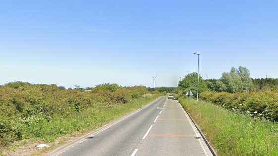 A stretch of road with a car approaching