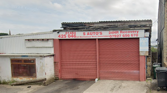 Google Maps image showing the outside of S Autos garage on Bulay Road in Huddersfield, with two large red garage doors and offices in a white building to the left.