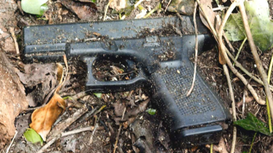 A black Glock pistol lying on the ground.