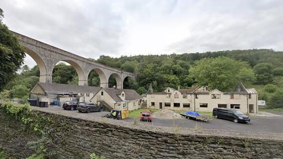 A google streetview of the derelict building in Chelfham. You can see the building and the bridge in the background.