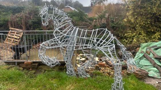 The Appleby Stallion sculpture. The metal sculpture is in the shape of a horse with a front paw lifted. 