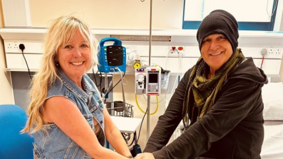 The Alarm singer Mike Peters holds hands with his wife Jules on his hospital bed