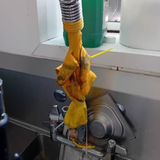 A rubber glove strapped to a kitchen tap