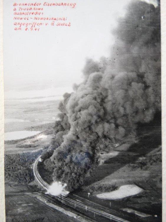 A cloud of dark smoke rises from the landscape near a curved railway line in the lower left. Handwriting in red pen, in German, gives further details in the blank space of the sky, upper left.