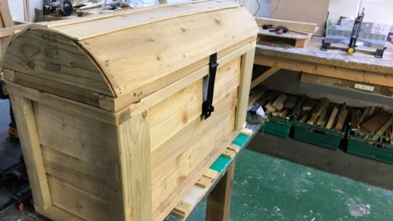 An wooden treasure chest in a workshop.