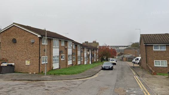 A street view image of a a residential street with brick properties either side of the road.