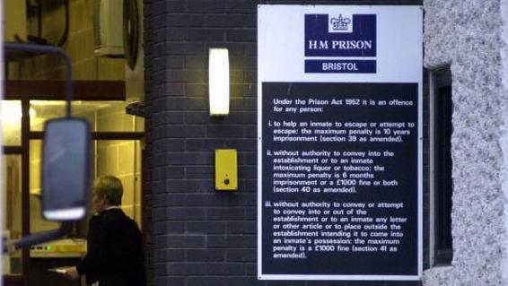 Bristol prison. The image shows an entrance, with a prison officer in the background, next to a sign explaining the Prison Act 1952.