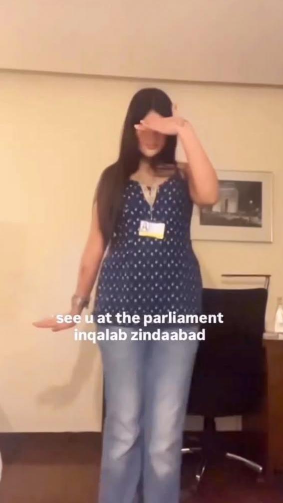 A girl posing for the camera, as she shows the outfit she is wearing to the protest