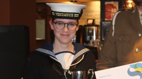 A young woman is pictured in glasses and maritime uniform