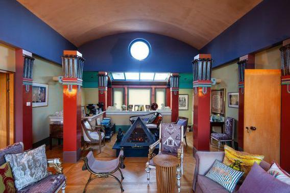 A living room with freestanding columns and a pyramidal fireplace