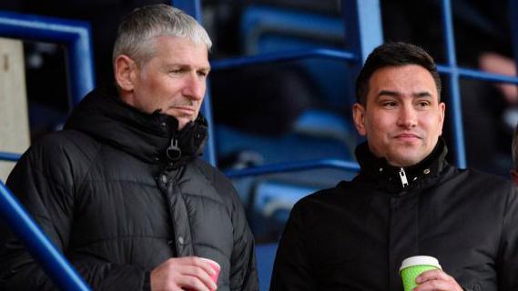 Jez George, left, and Liam Scully, in the stands looking towards the pitch