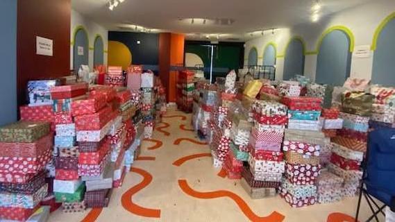 A room full of stacks of shoeboxes wrapped in Christmas wrapping paper.
