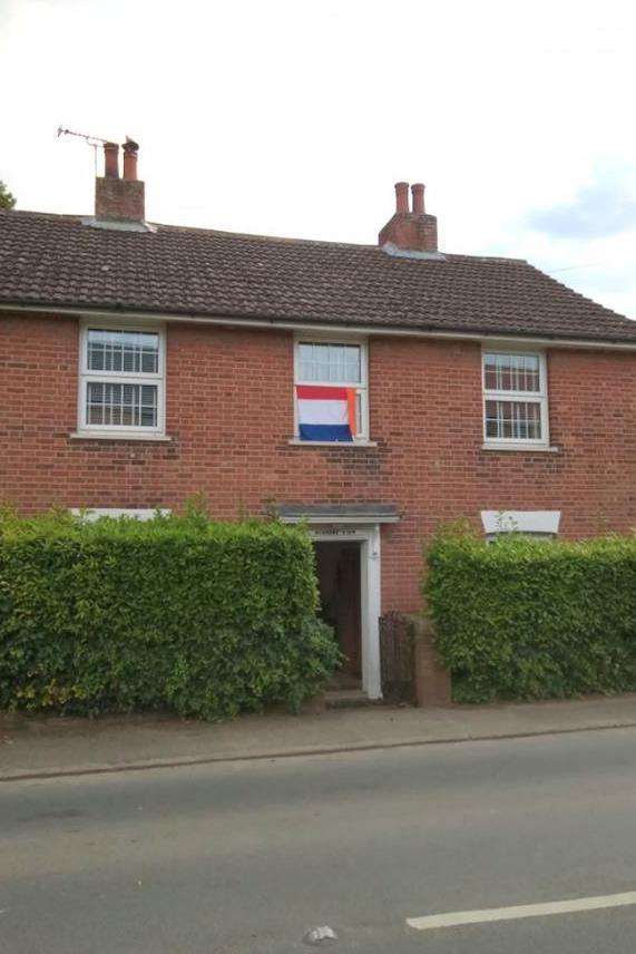 Gerda Newsham's house displaying a Netherlands flag in the middle upstairs window next to two other windows