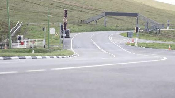 The Mountain Road looking ahead to a metal footbridge