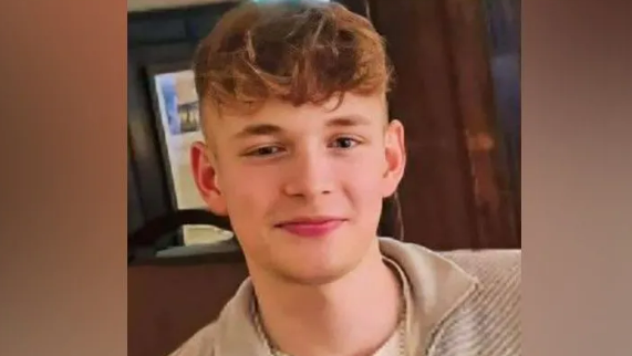 A picture of George Rabbett-Smith wearing a brown top and smiling