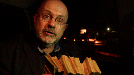 John Sweeney holds a stack of Venezuelan Bolivars